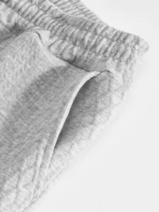 Close up detail of mens grey jacquard casual trousers pocket and elastic waistband.