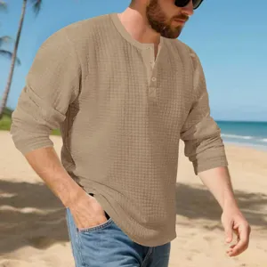 Close-up of men's long sleeve jacquard textured henley shirt in casual beach setting.