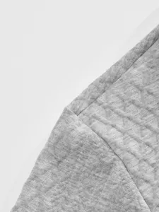 Detailed close-up view of grey jacquard fabric showing fine texture and neat stitching.