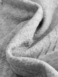 Grey jacquard knit fabric close up detail, soft textured cotton material for men clothing.