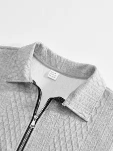 Close-up detail view of grey textured jacquard men polo sweatshirt collar and zipper.