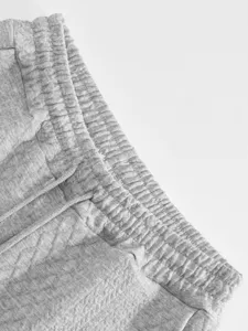 Close-up detail shot of grey jacquard knit casual lounge pants elastic waistband with drawstring.