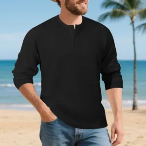Detail shot of men's black waffle knit long sleeve Henley shirt beach scene background.
