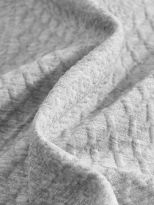 Grey jacquard fabric detail close-up showcasing unique texture and soft cotton material.