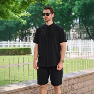 Gros plan sur le détail du tissu de la chemise noire homme à col mao et manches.