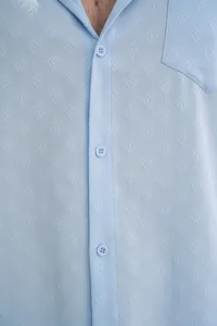 Détail de chemise jacquard pour homme bleu clair avec patte de boutons et poche.