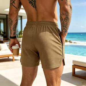 Detailed view of men's breathable mesh athletic shorts in khaki by the outdoor swimming pool.
