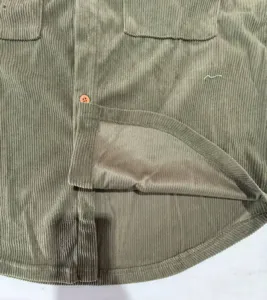 Détail du tissu de chemise en velours côtelé avec boutons et finitions soignées.