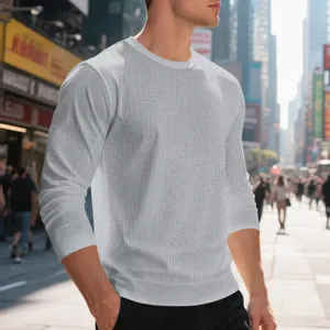 Detailed view of men's grey waffle knit long sleeve crewneck shirt in urban street setting.