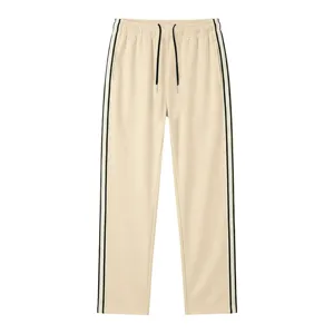 Vue détaillée du pantalon décontracté beige avec bandes latérales noires et cordon.