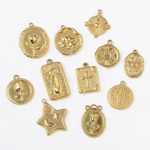 Detailansicht verschiedener goldener Anhänger aus Edelstahl im Vintage-Stil mit Prägung.