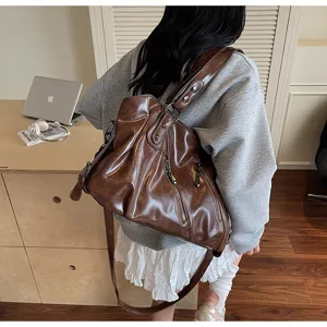 Brown leather large capacity shoulder bag for women, slouchy tote and crossbody design detail.