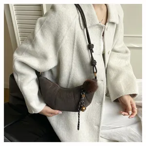 Sac à bandoulière marron chic pour femme, élégant sac croissant tendance avec pompon peluche.