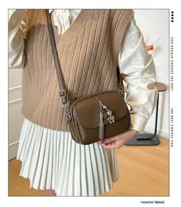 Brown leather crossbody bag with tassel and bear pendant, ideal for daily casual wear.