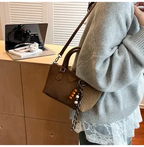 Borsa a tracolla plissettata marrone vista dettaglio con manico e ciondolo di perle.