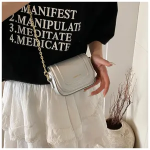 Metallic silver mini cross-body bag detail, showing premium textured leather and chain.