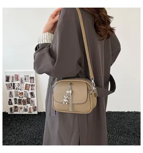 Casual retro women crossbody shoulder bag with stylish tassel and cute bear pendant detail.