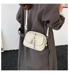 Minimalist casual crossbody bag with tassel and bear pendant, retro fashion commuter shoulder bag.