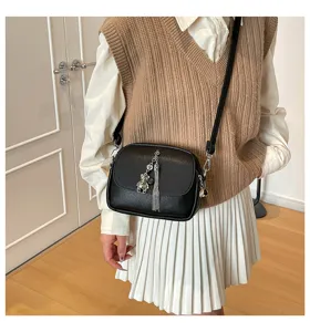 Black leather cross-body bag with metal tassel and bear pendant for women daily casual commute