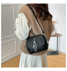 Black PU leather shoulder bag with chic tassel and bear charm for women daily commuting style.