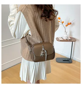 Women brown leather crossbody bag casual retro shoulder bag with tassel and bear pendant.