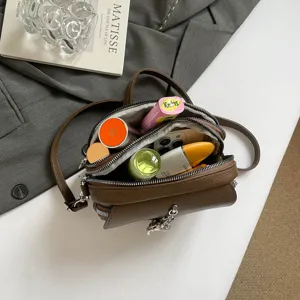Retro brown leather crossbody bag for women, stylish round shoulder handbag with zipper design.