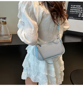 Detailed shot of a stylish light blue textured shoulder underarm bag with a chic chain strap.