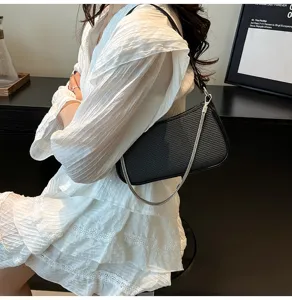 Stylish black shoulder bag for women, trendy underarm bag with metallic chain strap design.
