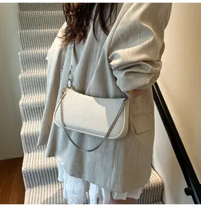 Chic white textured baguette shoulder bag with stylish metal chain strap for women.