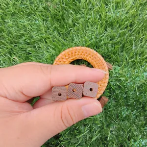 Close-up detail of natural wooden square barrel beads with center hole for DIY jewelry making.