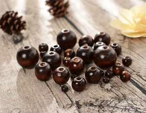 Gros plan de perles en bois brun foncé pour loisirs créatifs, tailles variées éparpillées.
