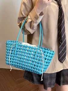 Stylish blue PVC woven tote bag with white drawstring pouch, ideal for summer beach.