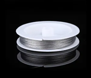 Close-up of steel beading wire wrapped on white spool, ideal for DIY jewelry making.