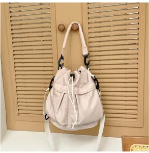 Casual solid color bucket bag with drawstring closure and shoulder strap for daily use.
