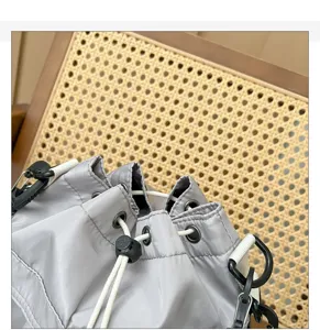 Close up detail of the grey drawstring shoulder bag with white cords and hardware
