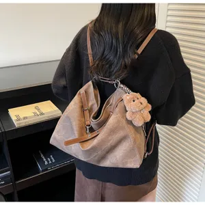 Detailed view of retro matte convertible women backpack tote bag with cute plush bear pendant.