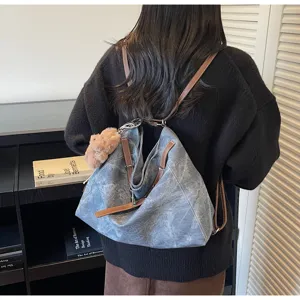 Vintage washed canvas backpack detail, multi-way shoulder bag with brown leather straps and cute furry charm.