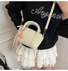 Chic litchi grain mini handbag with top handle and pink heart charm for women trendy.