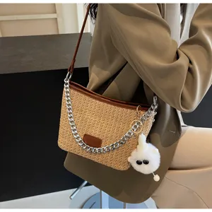 Stylish straw woven shoulder bag for women, featuring a chic chain strap and fluffy charm.