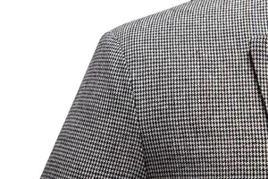Detalle de traje de negocios para hombre, tejido con patrón pata de gallo clásico, elegante.
