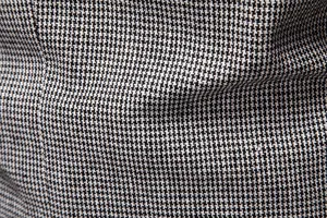 Primer plano detallado de la clásica textura de tela de pata de gallo para traje de hombre.