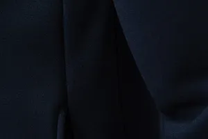 Detailed view of the dark blue fabric texture and precise stitching of the casual hoodie.