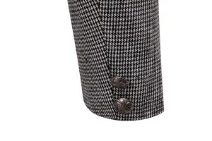 Detalle de puño de chaqueta de hombre con tela de pata de gallo en blanco y negro y botones