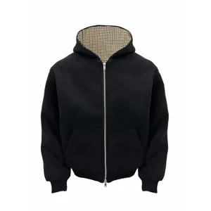 Gedetailleerd overzicht van zwarte hoodie met geruite voering en geribbelde boorden.