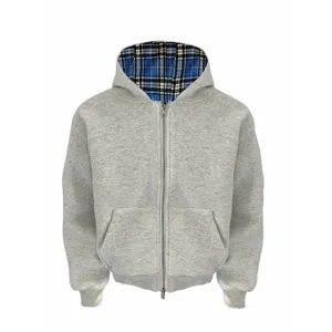 Gedetailleerd overzicht van de grijze hoodie met stijlvolle blauwe ruitvoering en metalen rits.