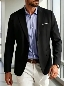 Detailed shot of a sleek black blazer styled with a light blue shirt and clean trousers.