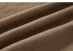 Gros plan détaillé du tissu pour pull en tricot pour hommes, en matière kaki texturée.