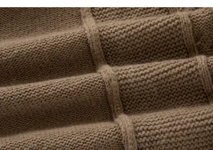 Gros plan sur les details de la texture du tissu de pull en tricot marron pour homme.