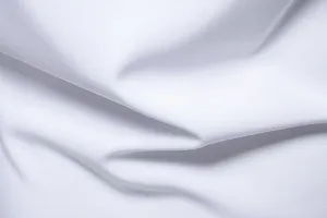 Primo piano della texture del tessuto bianco che mostra drappeggi morbidi e trama fine.