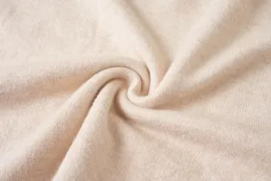 Toma de primer plano y detalle de suave tejido de punto beige con textura de mezcla de lana.